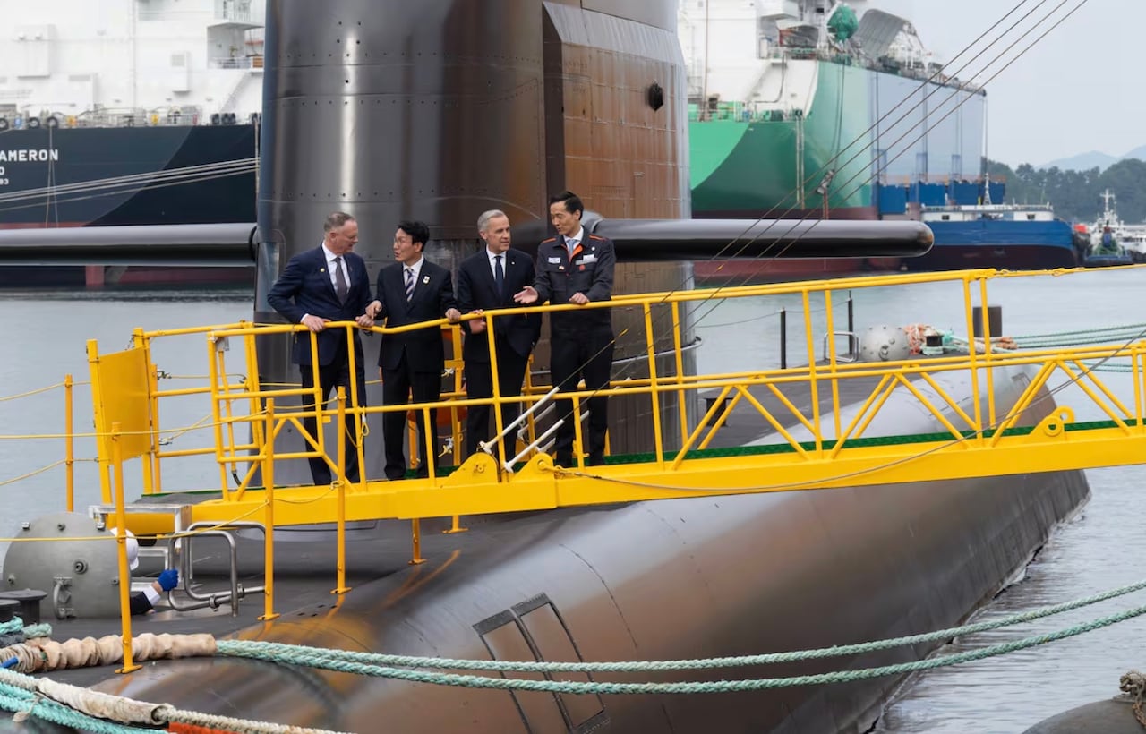 People tour a submarine on the water.