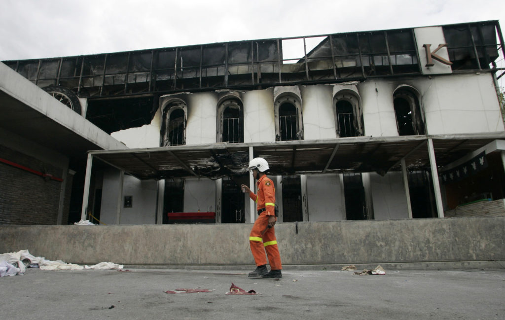 A rescue worker walks past the wreckage of Santika Club in Bangkok