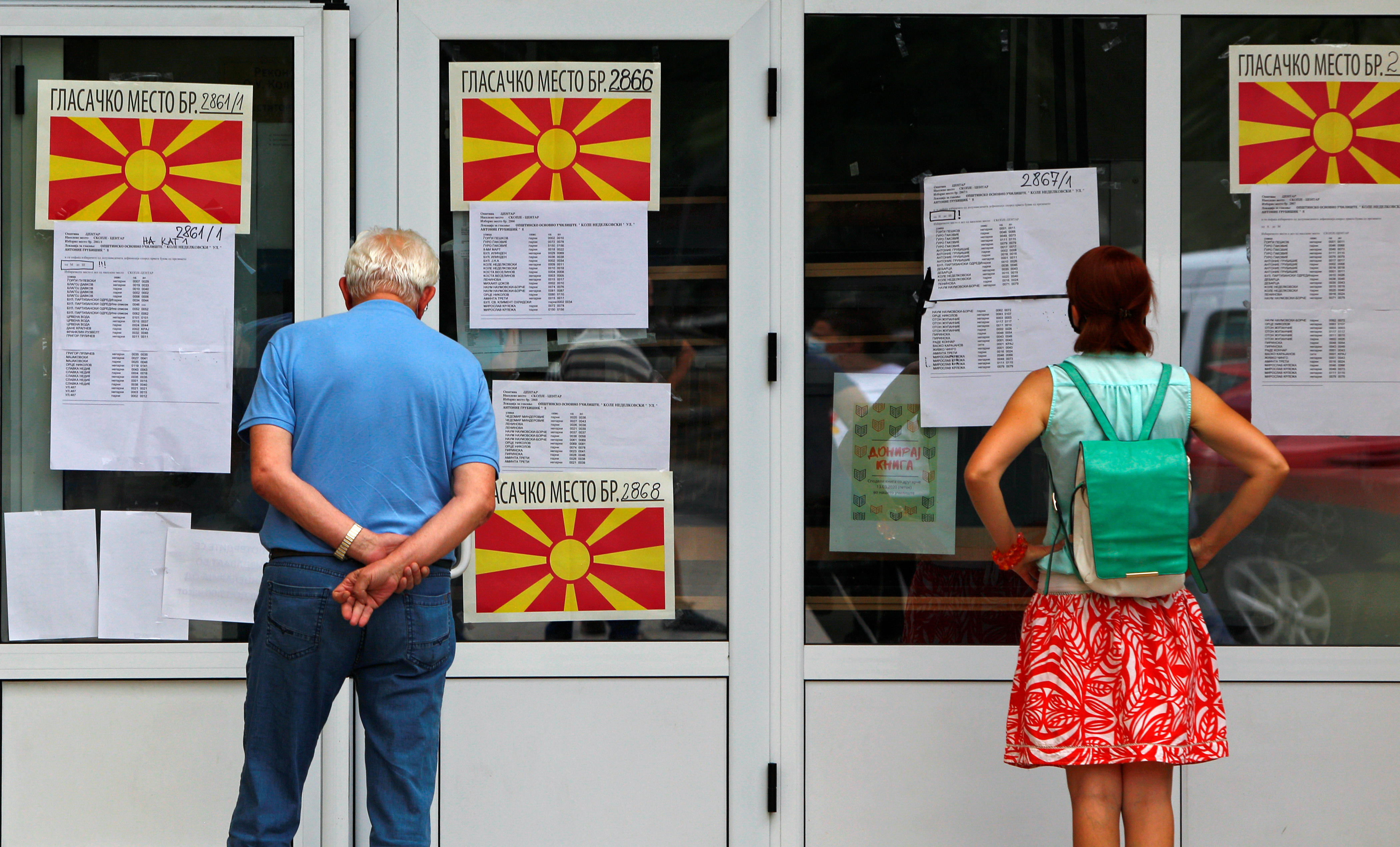 people looking at vote information in a window