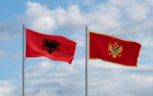 Two flags are flying side by side against a partly cloudy sky. The flag on the left is bright red with a black double-headed eagle in the center (the flag of Albania). The flag on the right is also red but has a gold border and a golden double-headed eagle with a shield on its chest (the flag of Montenegro).