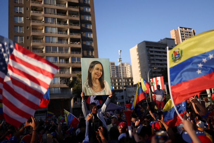 A person holds up an image depicting Venezuelan opposition leader María Corina Machado in Santiago, Chile, on January 3, 2026.