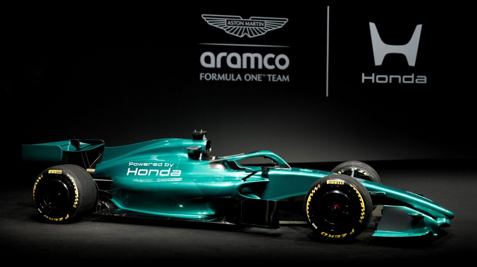 Honda unveils 2026 F1 power unit for Aston Martin The Aramco Formula One Team vehicle on a stage in a promotional pic, with the team brand and logo in green behind.