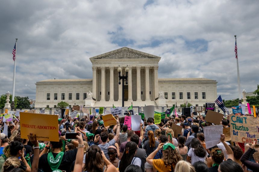 WASHINGTON, DC - JUNE 24: People protest in response to the Dobbs v Jackson Women's Health Organization ruling in front of the U.S. Supreme Court on June 24, 2022 in Washington, DC. The Court's decision in Dobbs v Jackson Women's Health overturns the landmark 50-year-old Roe v Wade case and erases a federal right to an abortion.