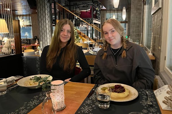 Marley Hines, left, with host family “sister” Tanja eating sauteed reindeer and reindeer pasta in Rovaniemi, Finland.