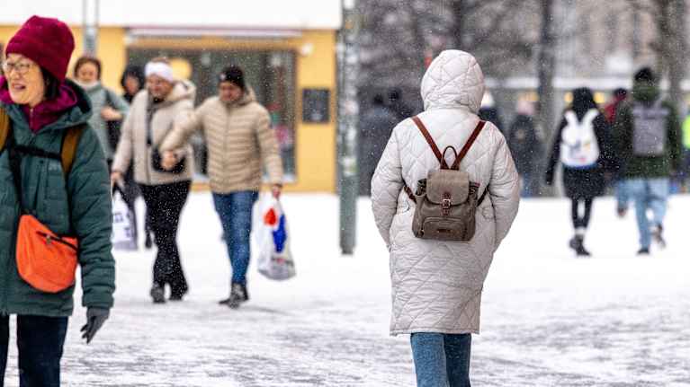 Photo shows a person walking on the street in Helsinki.