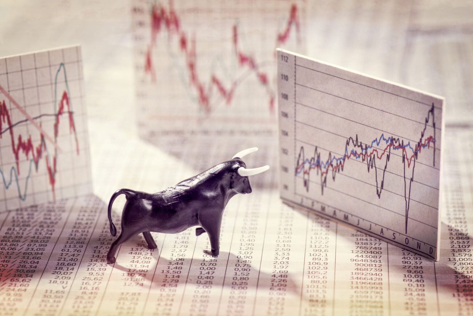 The S&P 500’s Best Stock in 2025 May Soar in 2026 as the Artificial Intelligence (AI) Boom Continues (Hint: Not Palantir) A bull figurine standing on newsprint is surrounded by index cards showing stock price chart.