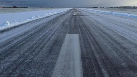 City of Derry Airport Shows an airport runway with snow on either side