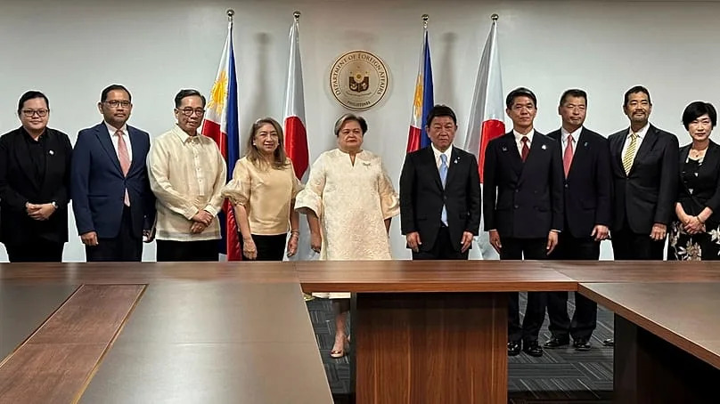 Japanese Foreign Minister Toshimitsu Motegi, center right, and Philippine Foreign Secretary Theresa Lazaro, center left, stand with their teams in Manila, Thursday, Jan. 15, 2