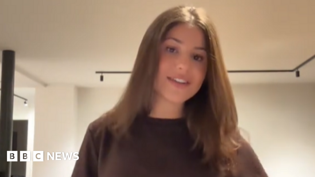 Charlotte Niddam poses in a brown t-shirt