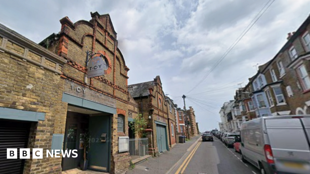 A brick building on a terraced, residential street. The signage on the building reads TCY.