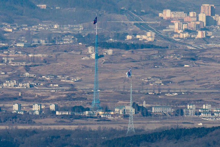 This image shows the South Korean national flag, Taegeukgi, right, at a South Korean border town in Paju, Gyeonggi Province, along with the North Korean national flag at a North Korean border town, Jan. 11. Yonhap