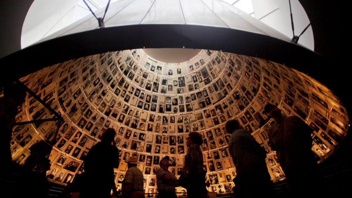 Visitors look at pictures of Jews killed in the Holocaust in the Hall of Names in the Yad Vashem Holocaust Memorial in Jerusalem, Sunday, April 7, 2013. The annual Israeli memorial day for the 6 million Jews killed in the Holocaust of World War II begins at sundown Sunday. (AP Photo/Sebastian Scheiner)
