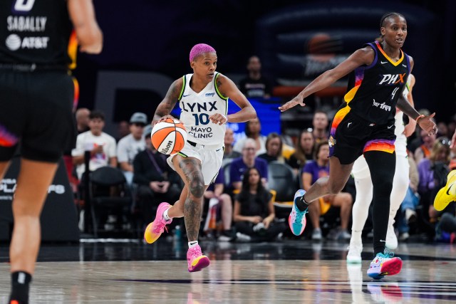 a basketball player with pink hair dribbles the ball down the court