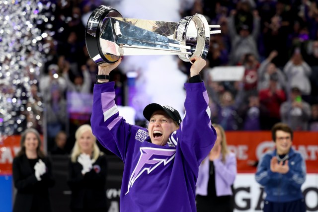 a hockey player holds high a trophy