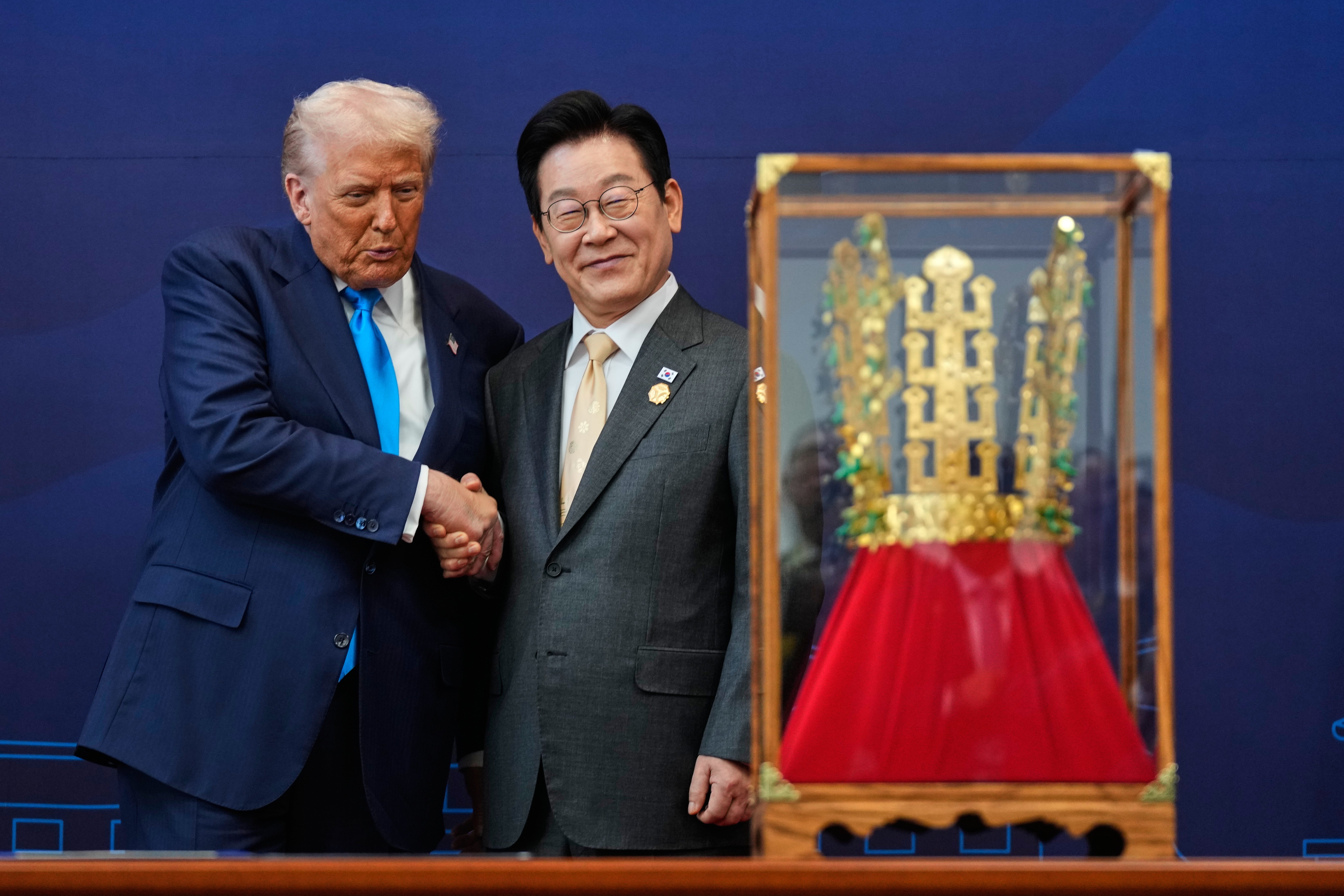 File President Donald Trump shakes hands with South Korean President Lee Jae Myung as he receives a gift of a gold crown and an award of the Grand Order of Mugunghwa, not seen, during a high honor ceremony at the Gyeongju National Museum in Gyeongju, South Korea, Oct. 29, 2025