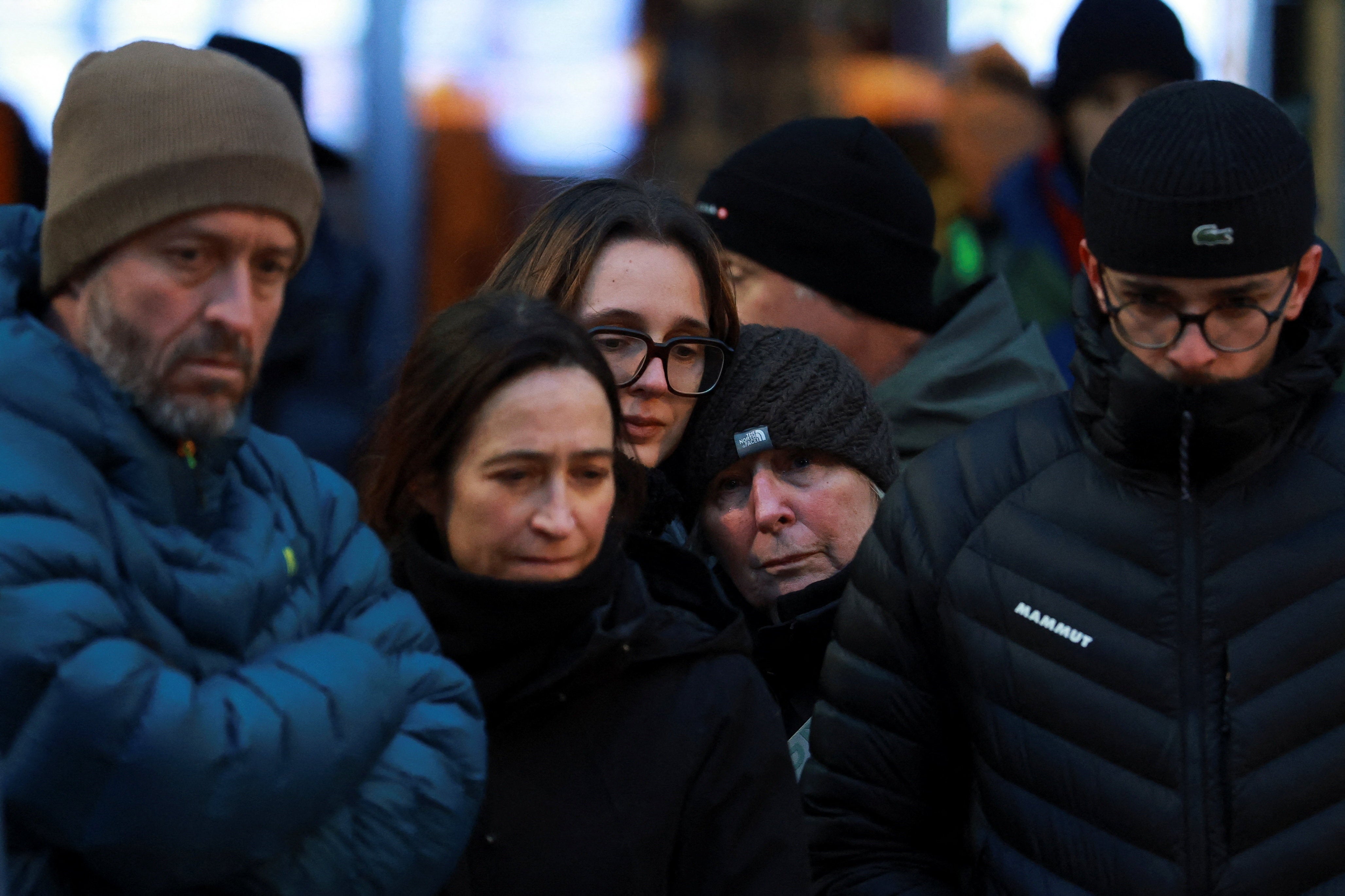 People react outside the Le Constellation bar, after a fire and explosion during a New Year's Eve party where people died and others were injured