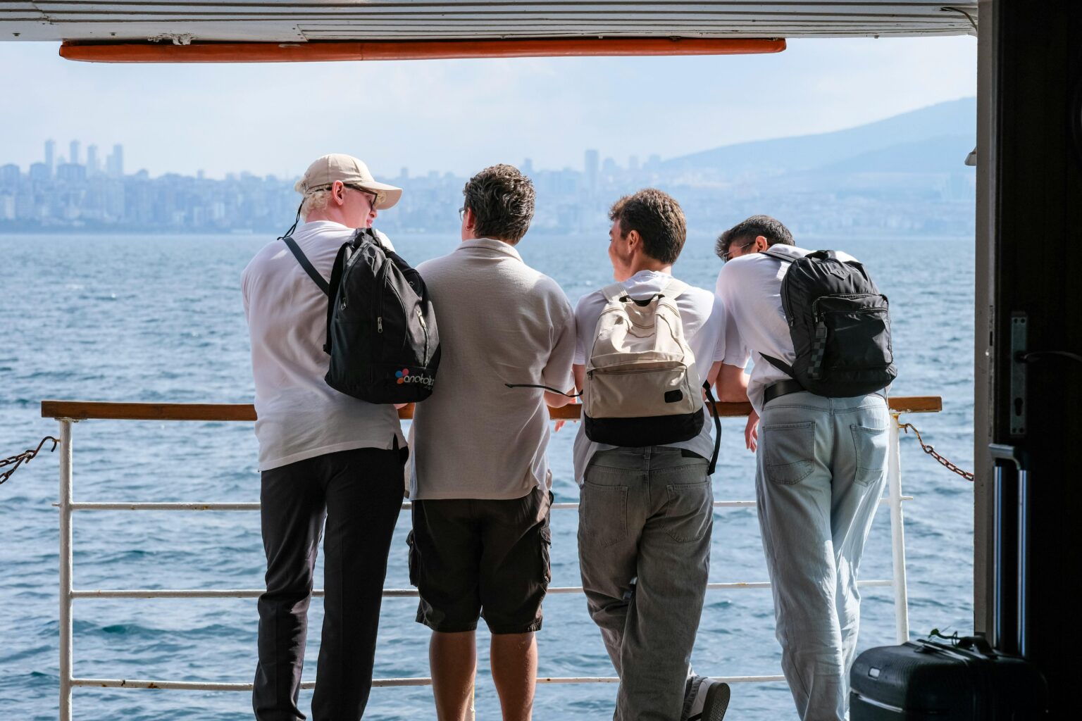 Family of men on a ferry boat; image by Murat Ak, via Pexels.com.