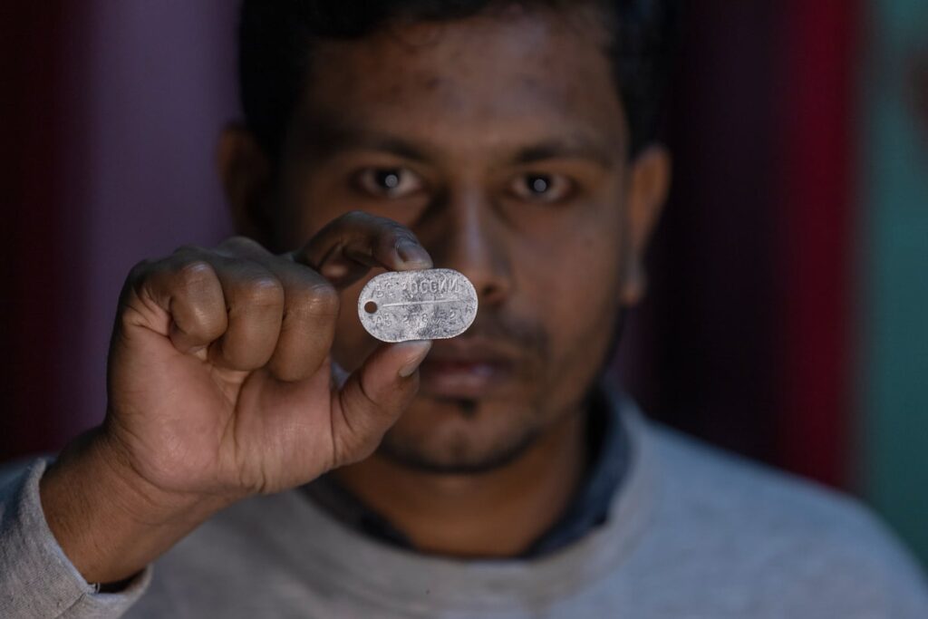 Maksudur Rahman, 31, who escaped after fighting for the Russian army, shows a Russian military dog tag.