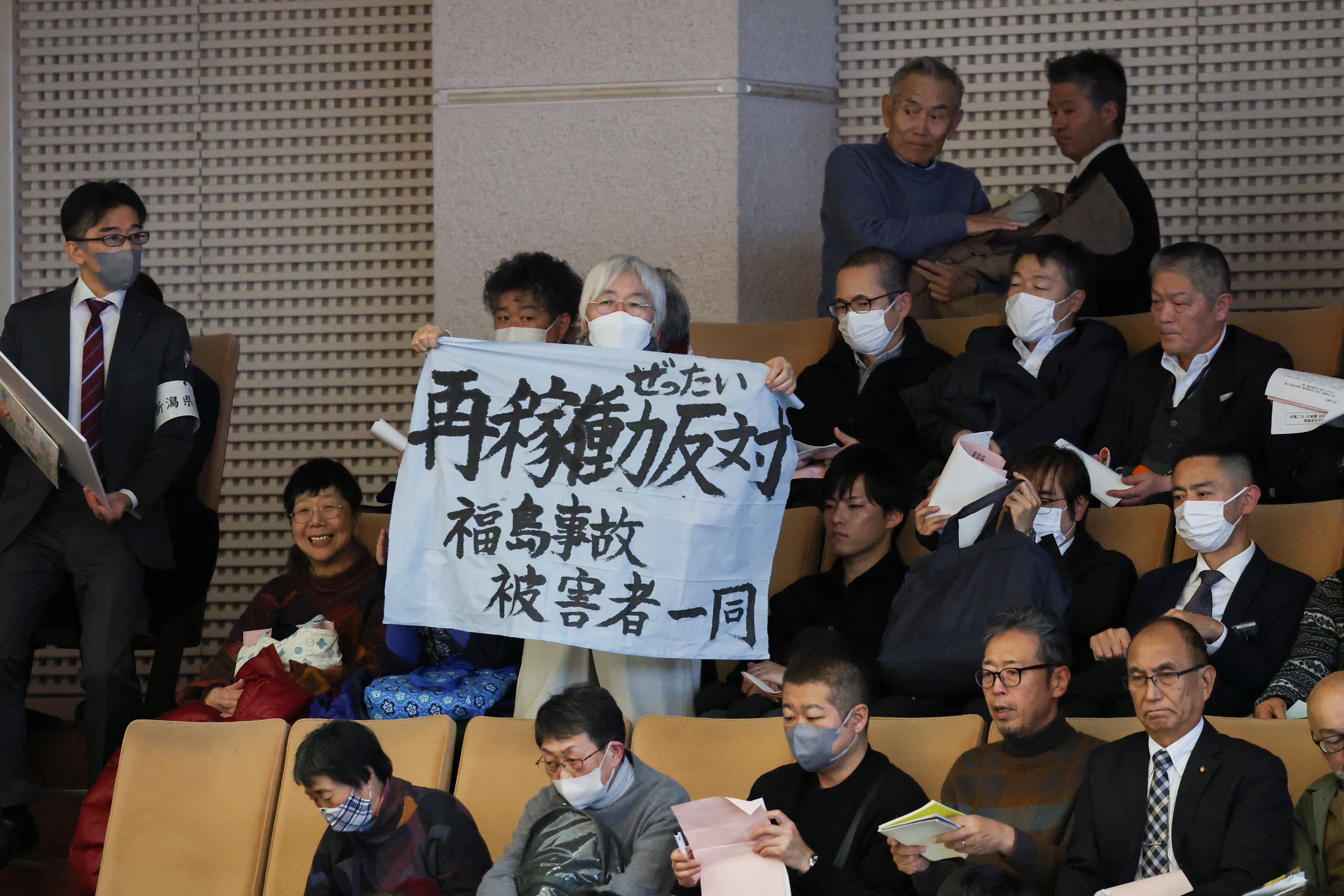 A woman holds a banner that reads, 