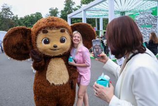 Muscovites take photos with a costumed Cheburashka at the VK music festival in Luzhniki. July 20, 2025.
