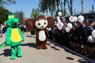 Performers in Gena the Crocodile and Cheburashka costumes perform at the opening of the Donetsk Children’s Railway in the occupied city. May 1, 2025