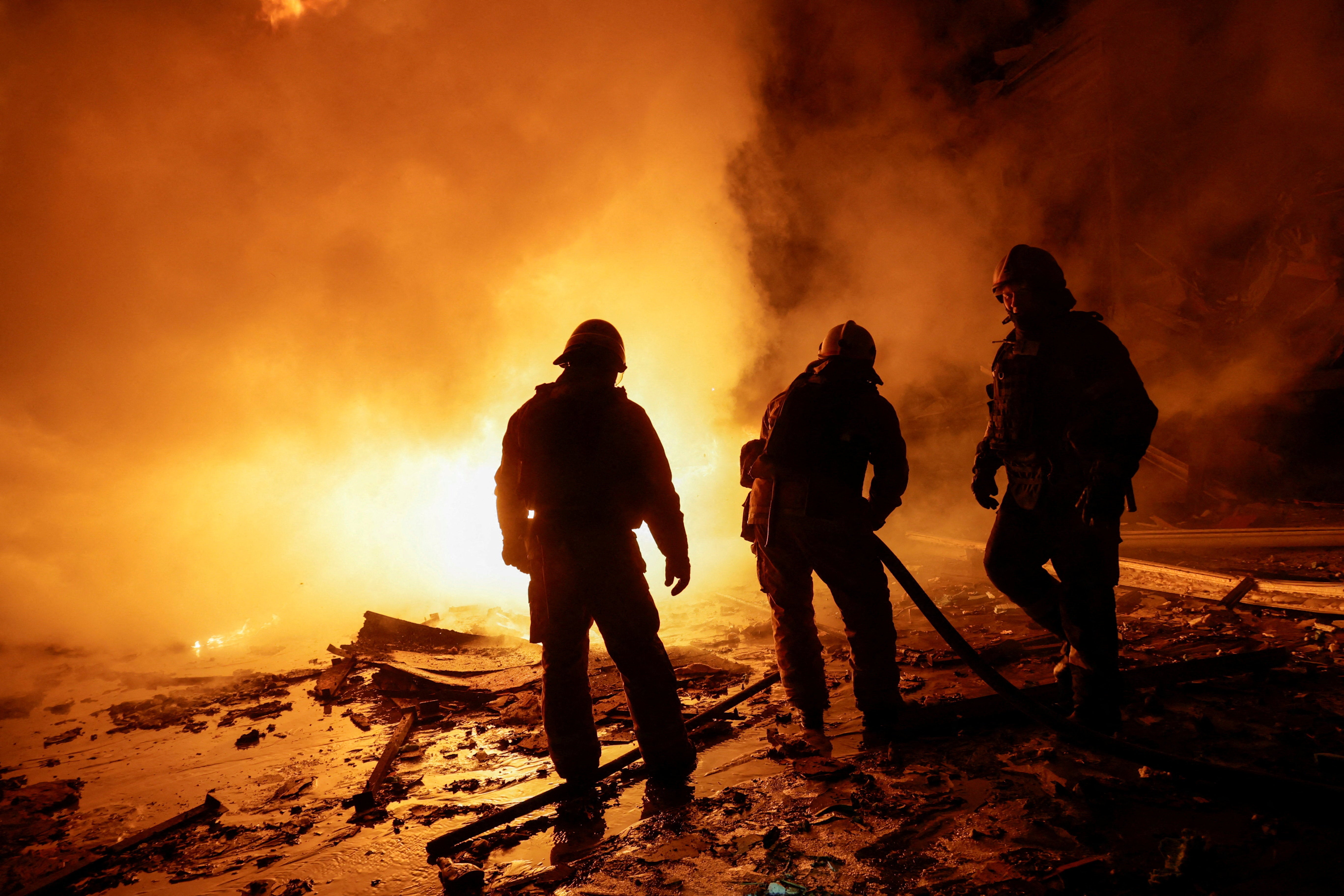 Firefighters work at the site of a logistics hub of a private delivery company hit by a Russian missile strike, amid Russia's attack on Ukraine, in Kharkiv, Ukraine, 13 January 2026