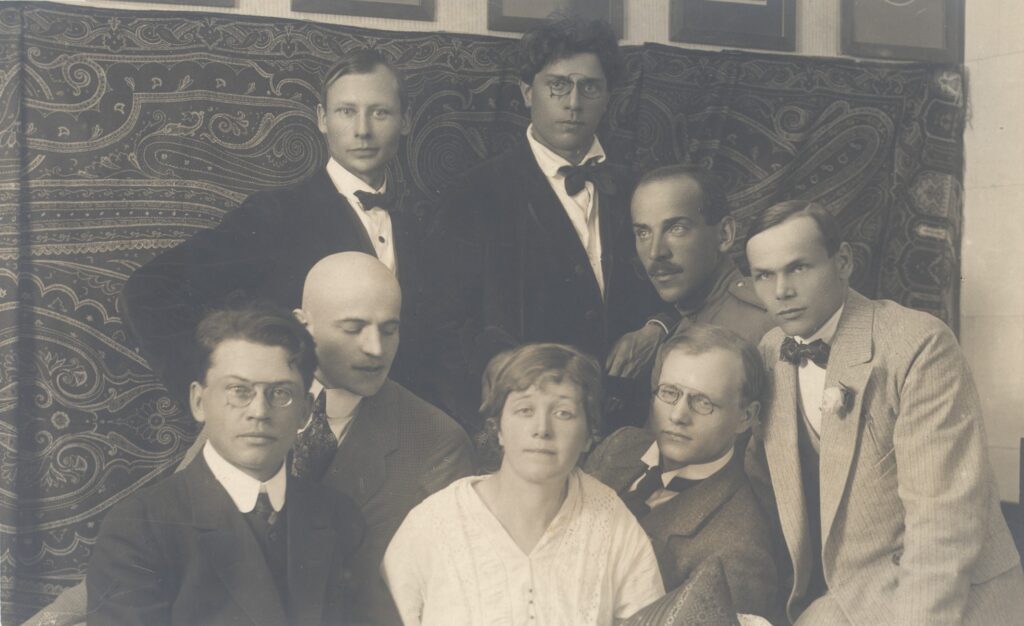 Henrik Visnapuu was a central figure in Estonia’s Siuru literary movement. Pictured here with fellow Siuru members: standing (from left) Peet Aren and Otto Krusten; seated (from left) Friedebert Tuglas, Arthur Adson, Marie Under, August Gailit, Johannes Semper and Henrik Visnapuu. Public domain.