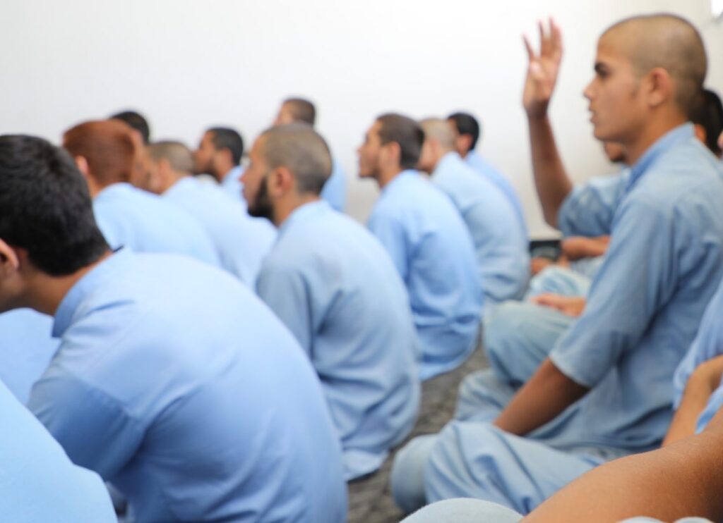 Men in light blue uniforms attend a session at an addiction treatment center in Afghanistan, where UNODC has distributed winter clothing and blankets with support from Malta. (Photo Credit: @UNODC_COAFG)