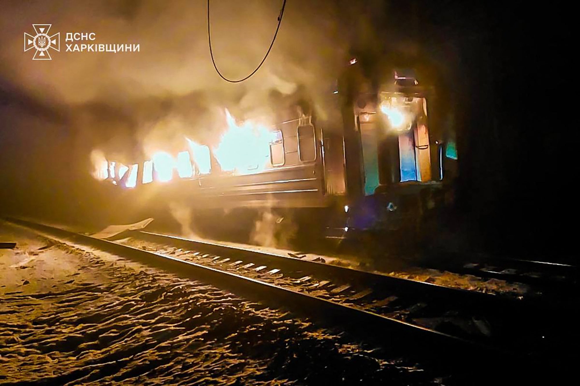 A burning train carriage following an air attack at an undisclosed location in the Kharkiv region