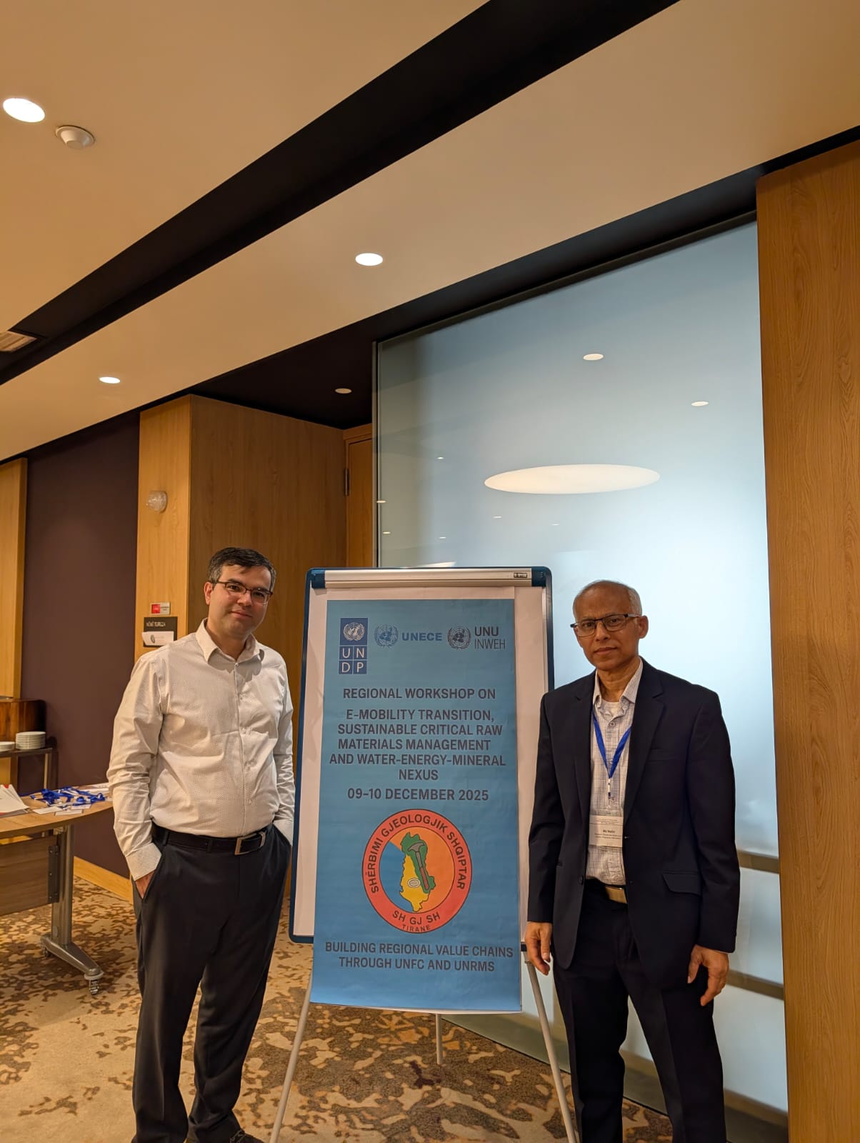 two men stand next to poster
