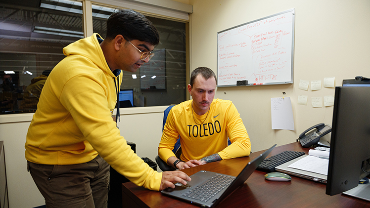 Yash Ghadge, left, a data science junior, works with Henry Davidson, assistant athletic director for student-athlete benefits and data analytics, in Davidson’s office in Savage Arena.