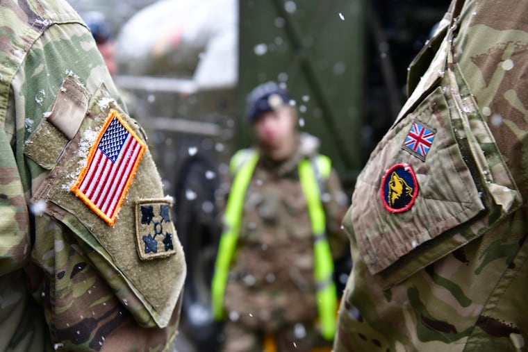 A British soldier and their American counterpart stand side by side after a news conference on a military exercise in Brueck, Germany, in February 2020.