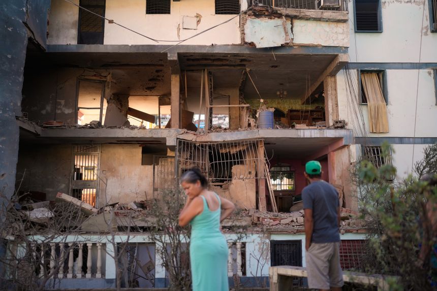 Residents look at a damaged apartment complex that neighbors say was hit during U.S. strikes to capture Venezuelan President Nicolás Maduro, in Catia La Mar, Venezuela, on January 4.