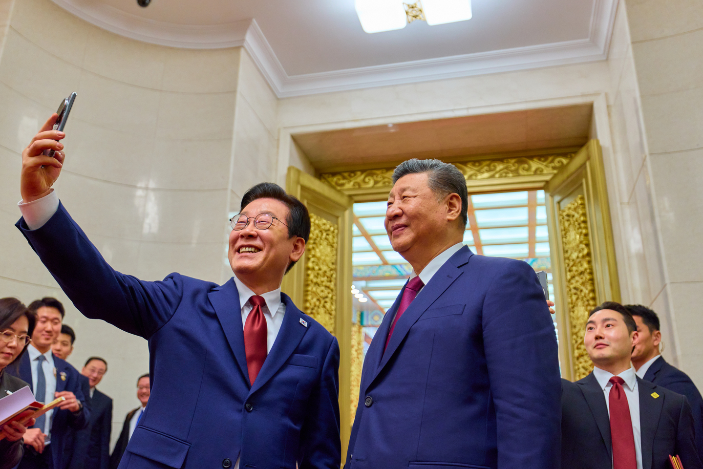 President Lee Jae Myung, left, and Chinese President Xi Jinping pose for a commemorative photo using a Xiaomi smartphone at the Great Hall of the People in Beijing on Jan. 5, following a state banquet. The phone was a gift from Xi to Lee during their summit in Gyeongju last year. [JOINT PRESS CORPS]