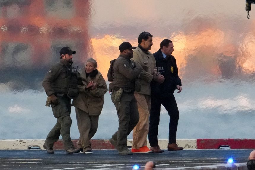 Law enforcement officials move captured Venezuelan President Nicolas Maduro and his wife Cilia Flores, second from left, out of the helicopter in New York on January 5.