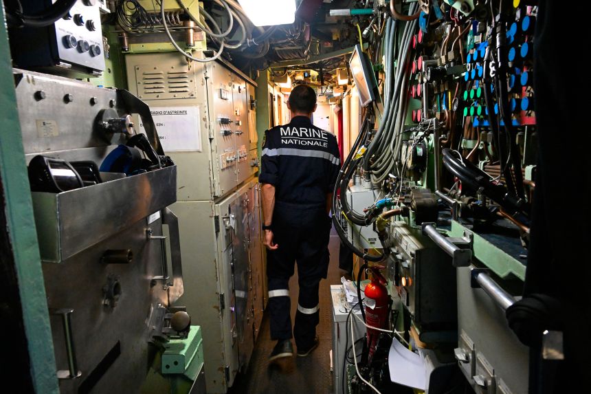 A sailor walks in the passageway of the nuclear attack submarine 