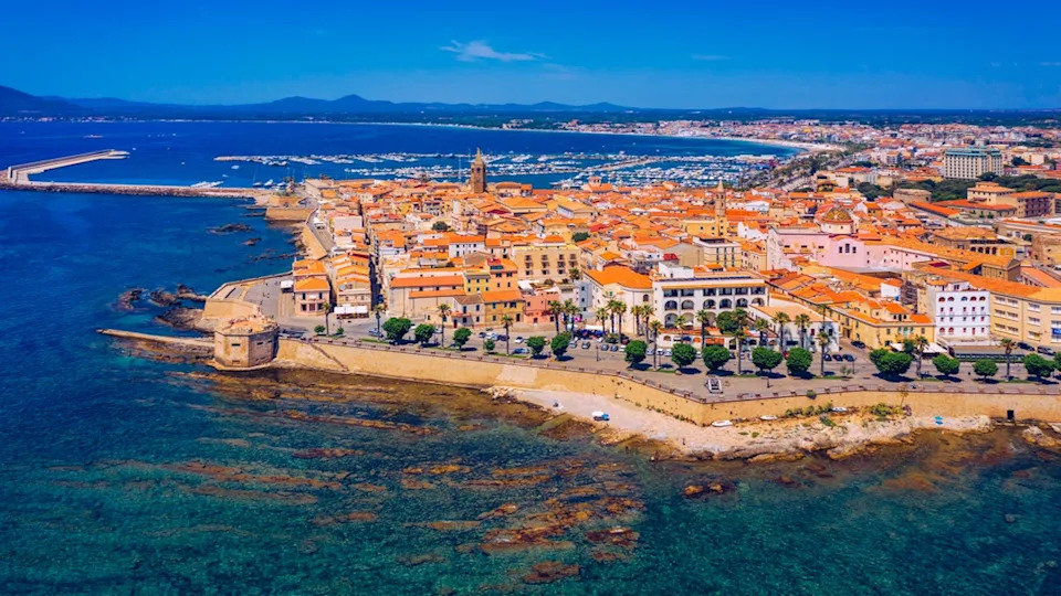 Aerial view over Alghero old town, cityscape Alghero view on a beautiful day with harbor and open sea in view. Alghero, Italy. Panoramic aerial view of Alghero, Sardinia, Italy.