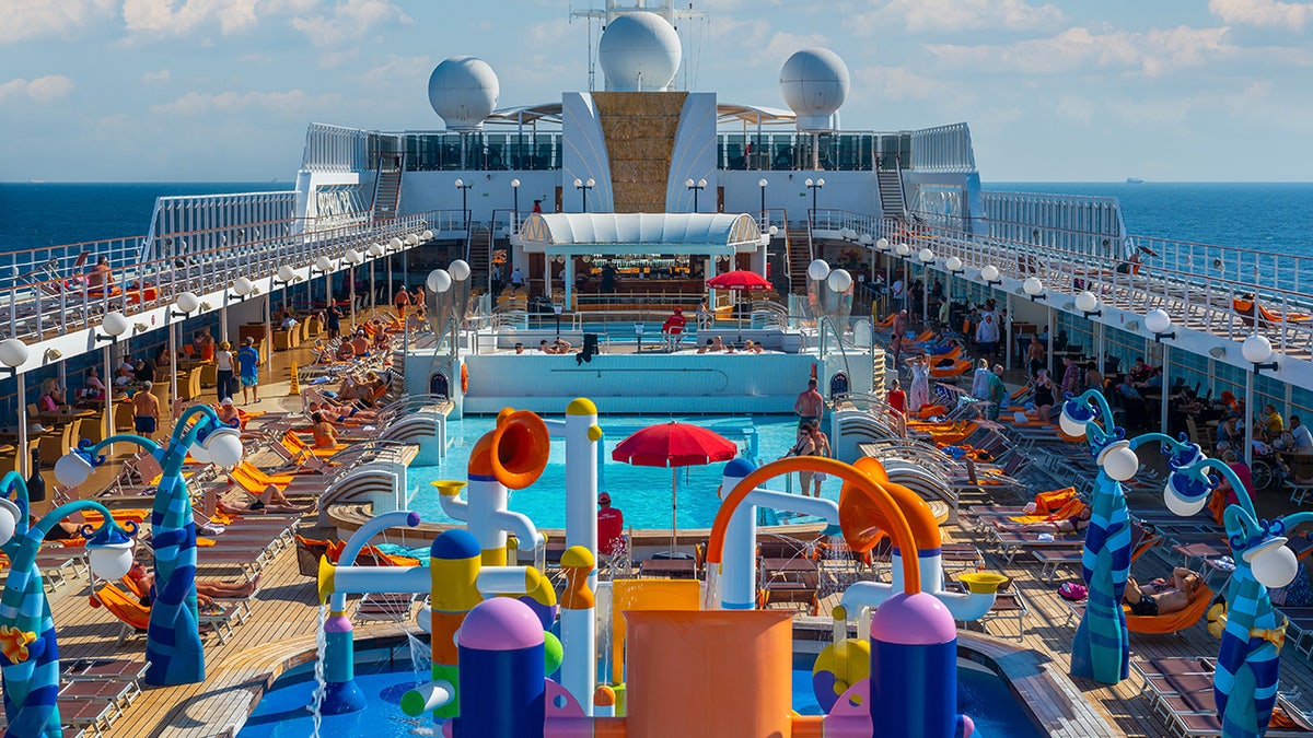 Colorful pool deck on cruise ship sailing at sea.