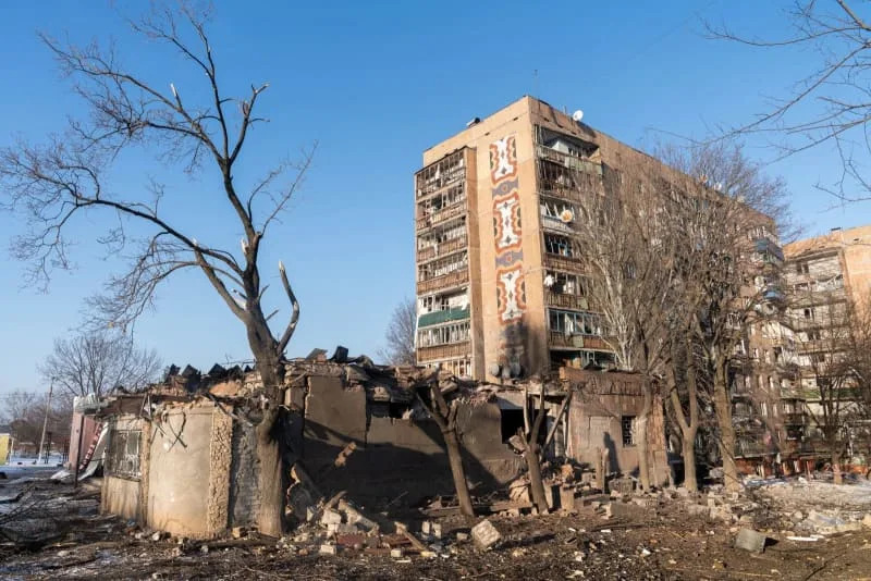 A destroyed low-rise building stands in front of a damaged residential apartment block following shelling in eastern Ukraine. Cameron Jones-Manley/ZUMA Press Wire/dpa