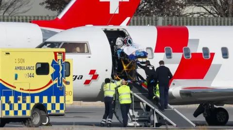 Reuters Casualties are lifted on to a aircraft in Switzerland on a stretcher