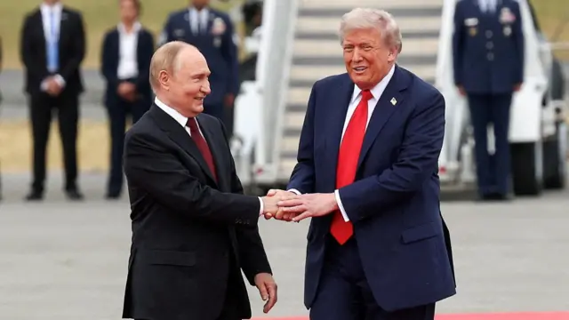 Vladimir Putin and Donald Trump shake hands on a runway