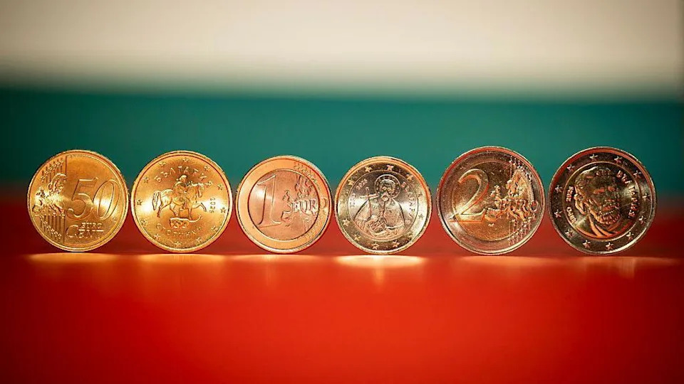 Close up of six gold coins showing the symbols on them, including a person on a horse and a face and a saint-type figure