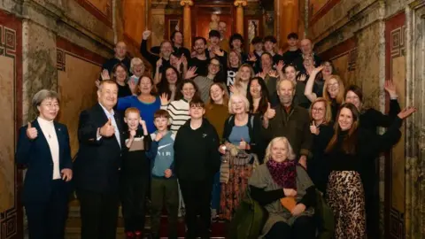 Vienna Tourist Board/Martin Morscher Residents from Dull at the Hotel Imperial in Vienna smiling and waving at the camera.