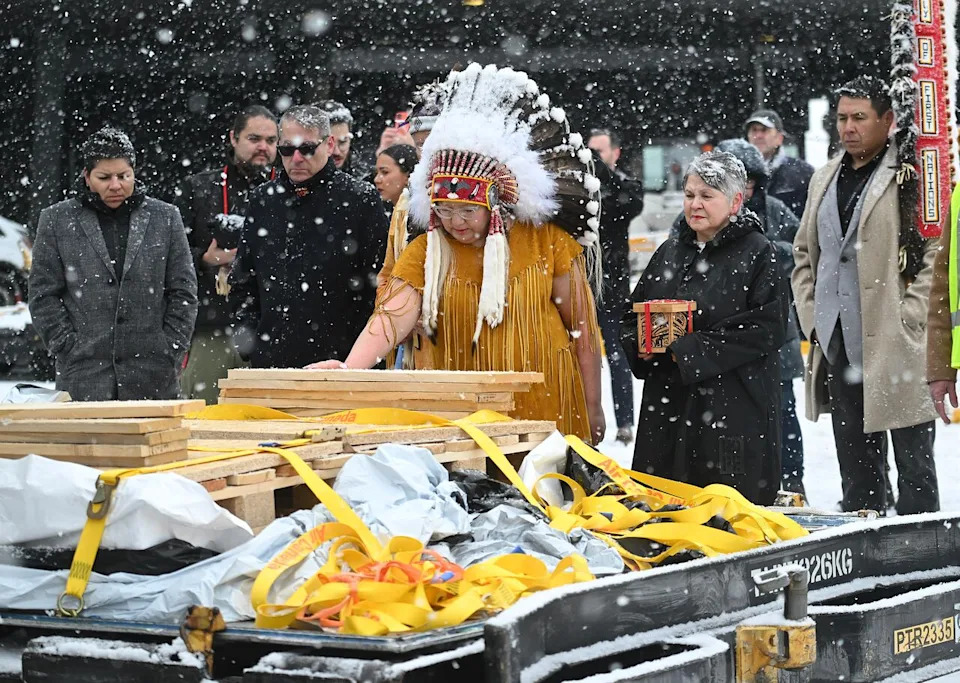 Assembly of First Nations National Chief Cindy Woodhouse Nepinak places her hand on indigenous and cultural artifacts at Trudeau Airport in Montreal, Saturday, December 6, 2025, after they were returned by the Vatican. THE CANADIAN PRESS/Graham Hughes