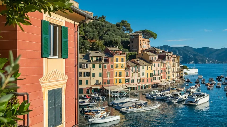 Picturesque resort town of Portofino in Liguria, Italy. Charming harbour with moored sailboats and luxury yachts surrounded by historic colorful buildings along the Ligurian coast.