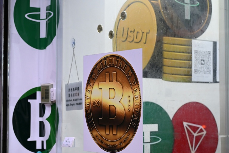 The symbols of bitcoin and the stablecoin Tether (USDT) are displayed at a cryptocurrency store