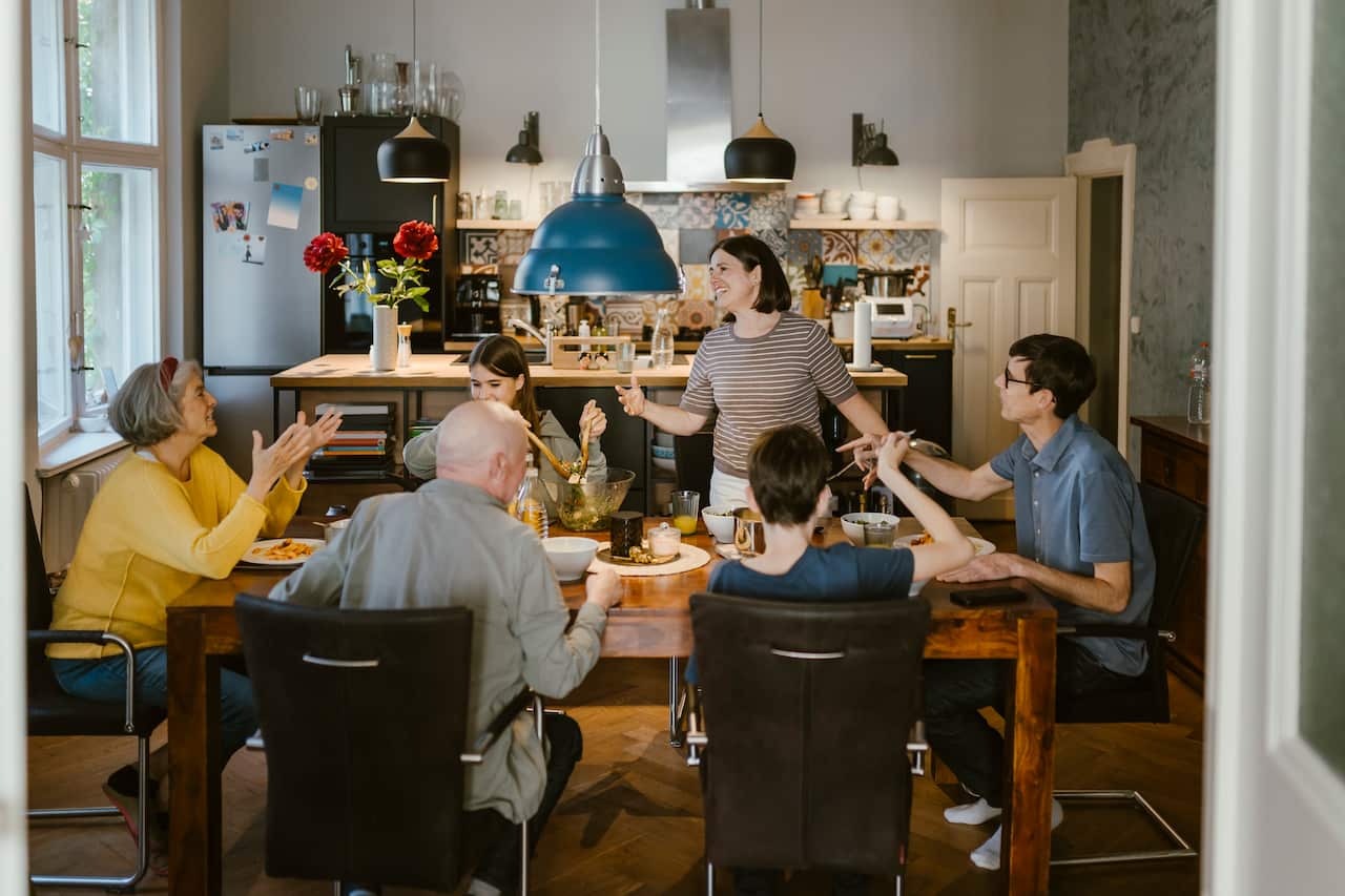 Happy multi-generation family enjoying while having lunch together at dining table in home