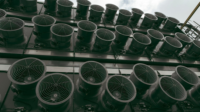 Rows of large industrial fans line the facade of a carbon removal plant’s collector containers.