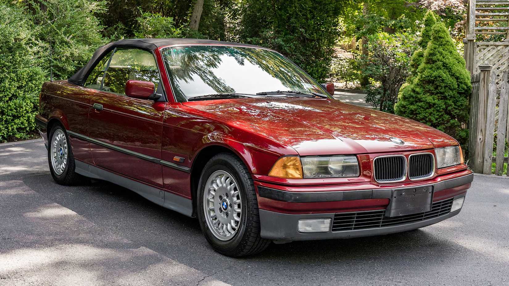 1995 BMW 325i Convertible in red parked on driveway
