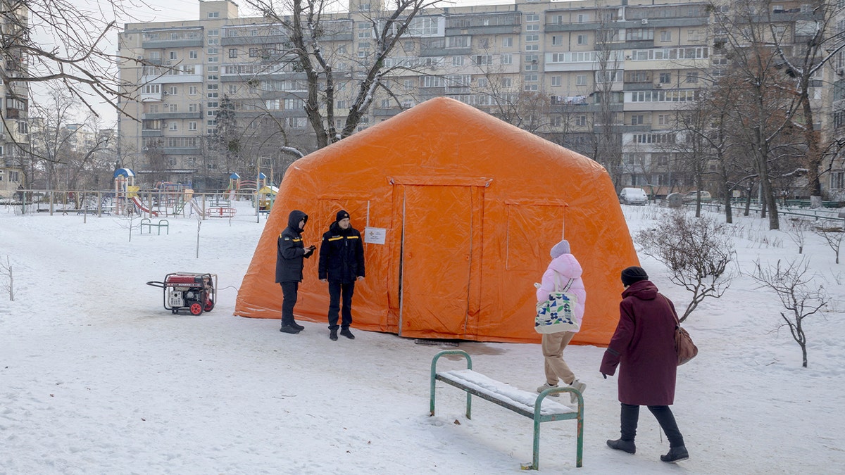 Residents walk toward a heated emergency shelter during extreme cold in a Kyiv neighborhood.